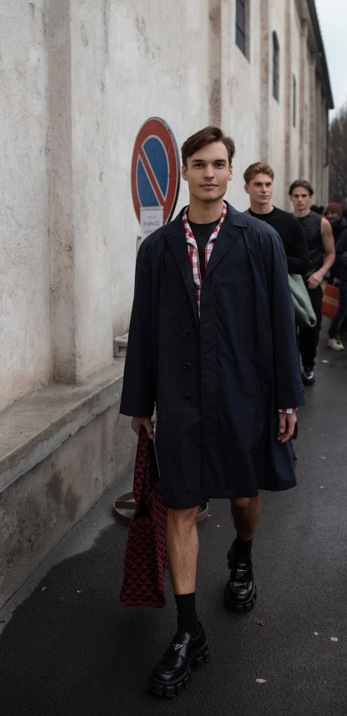gallery-4 Group of fashionable men strolling on a street in Milano, showcasing casual yet trendy style.