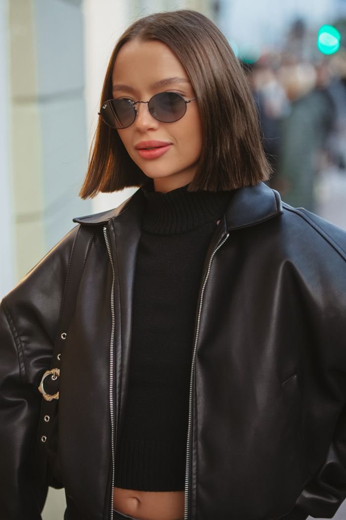 services-01 Fashionable woman wearing sunglasses and leather jacket on a city street.