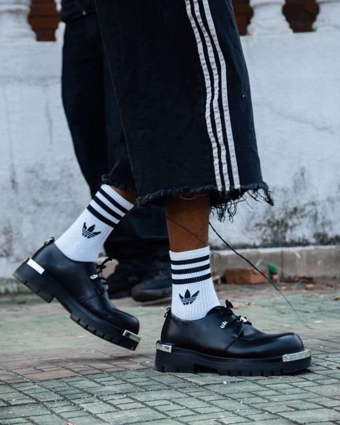 gallery-1 Close-up of trendy streetwear style featuring sneakers and striped socks, ideal for fashion inspiration.
