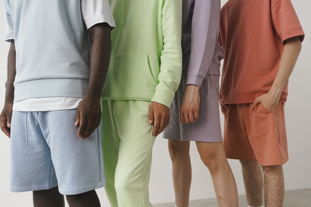 about-01 A close-up image showcasing a variety of pastel-colored men's fashion sweatshirts and shorts.