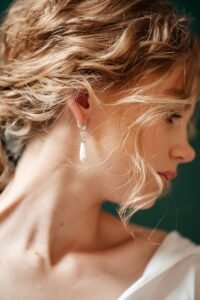 Pearl Wedding Earrings: The Ultimate Guide 2026 bride wearing gold pearl drop earrings with an up do hairstyle