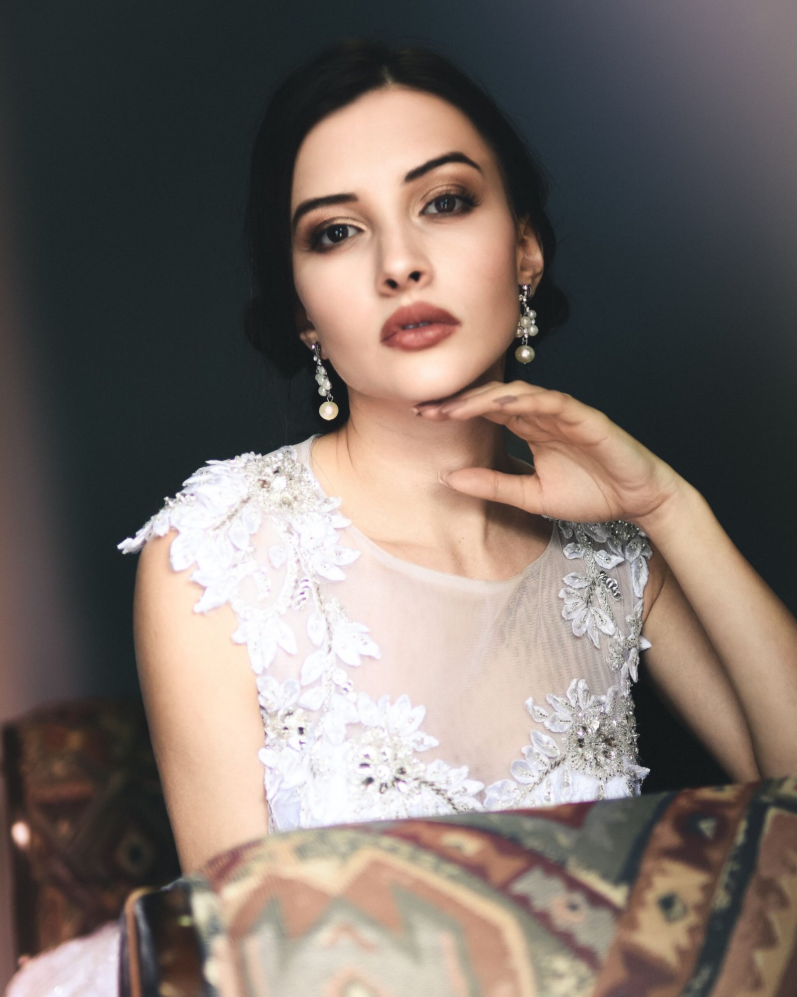 woman wearing gold pearl drop earrings at an evening event