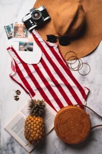 flat lay of halter one piece swimsuit styling accessories
