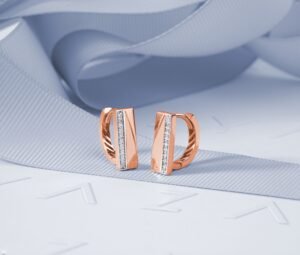 close up of 14k rose gold stud earrings on a marble surface, alt text "14k rose gold earrings showing warm pink tone
