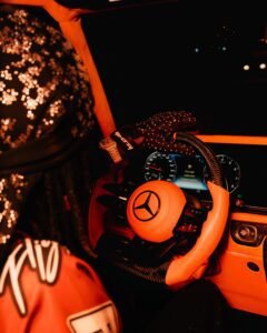 woman wearing brown leather driving gloves gripping a steering wheel