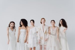 Bridesmaid Earrings: The Ultimate 2026 Gift Guide five bridesmaids in matching gold huggie hoop earrings standing in a row