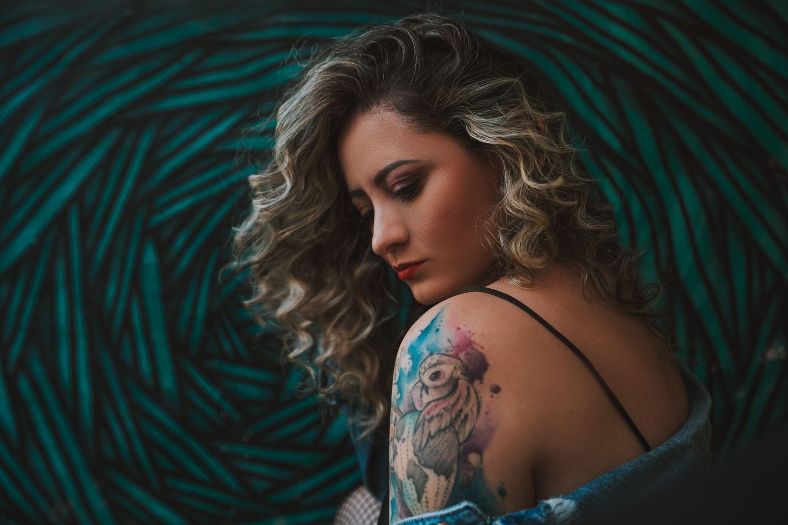 woman getting a fine line floral tattoo on her forearm in a tattoo studio