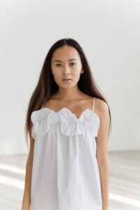 A-Line Tops: The Ultimate Fit Guide for Every Body (2026) woman wearing white a-line top with bust-flare silhouette against neutral background