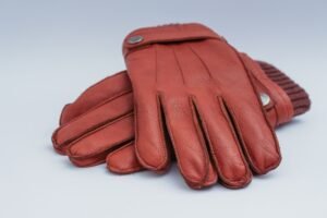 close up photo of hands applying leather conditioner to a leather glove