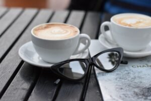 mirrored reflective sunglasses beside tortoise frame sunglasses on a wooden table