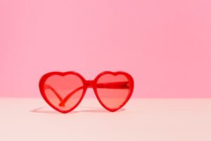 1980s style black wayfarer sunglasses on a red background