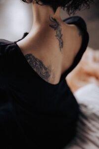 Tattoo Placement Ideas for Women: The Complete 2026 Guide woman with a vertical vine tattoo running along her spine from neck to mid back