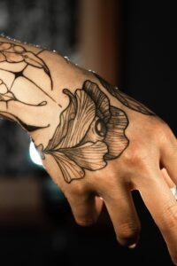 close up of fine line floral wrist tattoo on outer wrist