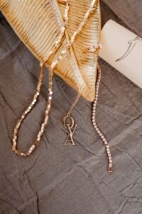 close up of mixed gold and silver dainty necklaces layered together