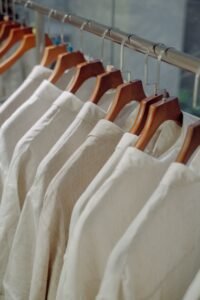 The Ultimate Guide to Womens Collared Tops (Updated for 2026) flat lay of five different womens collared tops in white cotton, chambray, and silk