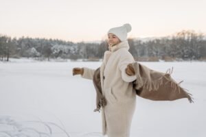 Womens Leather Gloves: The Complete Buying and Care Guide (2026) woman wearing cognac leather gloves with a camel wool coat