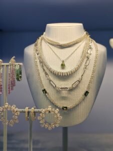 white gold necklace with a small pendant displayed on a velvet bust