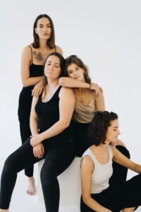 three ribbed square neck tank tops in white, black and beige on a neutral background