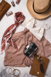  flat lay of black, white, navy, red, and light pink tank tops on a neutral background